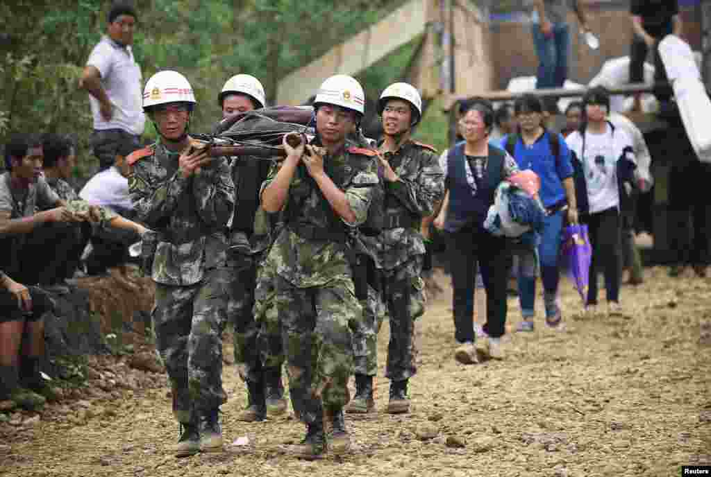 Paramilitary policemen carry an injured resident with a makeshift stretcher after an earthquake hit Longtoushan township of Ludian county, Yunnan province, Aug. 4, 2014.&nbsp;
