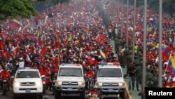Thousands of people follow the funeral parade of Venezuela's late President Hugo Chavez in Caracas, March 15, 2013.