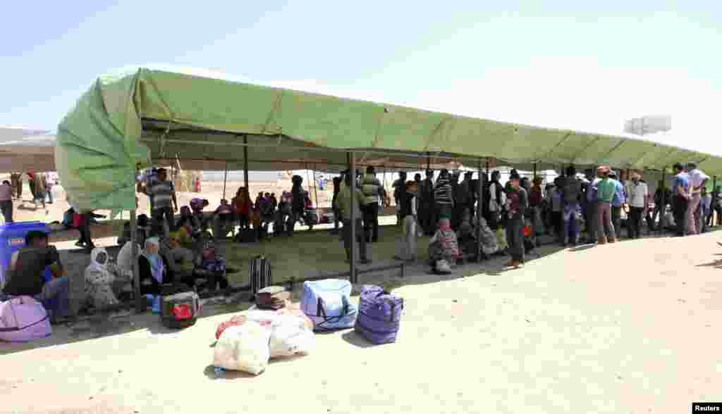 Syrian refugees fleeing the violence in their country, wait to cross the border into the autonomous Kurdish region of northern Iraq, August 25, 2013. 