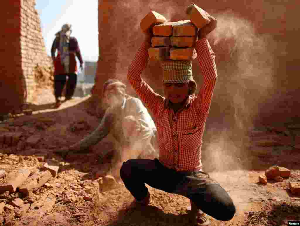 A worker stacks bricks on his head at a brick factory in Lalitpur, Nepal.