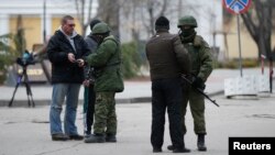 Petugas memeriksa dokumen dua orang jurnalis di dekat gedung parlemen di Simferopol, Krimea (foto: dok).