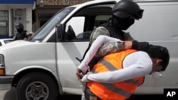 Alleged gunmen are lead by police officers before being presented to the media at the Baja California State Prosecutor office in Tijuana, Mexico, Saturday, March 19, 2011.