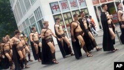 Men dressed in Spartan-style costumes walk through a commercial plaza in Beijing, July 22, 2015. 