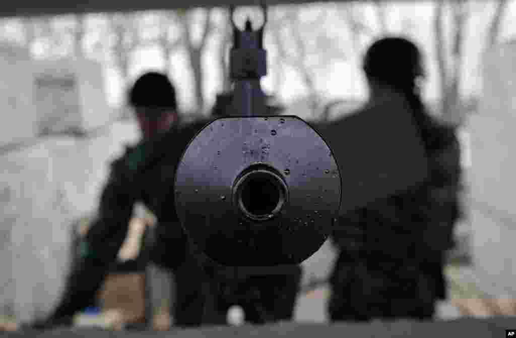 Servicemen stand inside a heavy machine-gun position at a Ukrainian army checkpoint near Kurakhove, Ukraine, March 3, 2015.