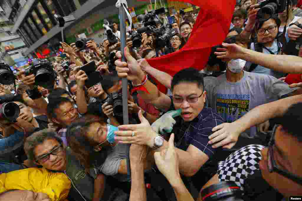 Pro-democracy protesters point and scuffle with a man (C) holding a Chinese flag who came to the protesters&#39; barricade to oppose them blocking roads at Mongkok shopping district in Hong Kong. 