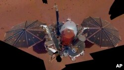 تصویر مریخ‌نورد «اینسایت» بر روی خاک مریخ که از ترکیب ۱۱ عکس که این کاوشگر با استفاده از بازوی رباتیک خود گرفته، تشکیل یافته است. ۶ دسامبر ۲۰۱۸ 