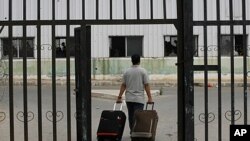 A Palestinian man carries suitcases to the waiting hall before entering Egypt through the Rafah border crossing, southern Gaza Strip, June 8, 2011.