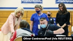 Aktris Jennifer Garner dan Ibu Negara AS, Jill Biden, menyapa warga yang sedang divaksinasi di Capital High School di Charleston, West Virginia, Kamis, 13 Mei 2021.(Foto: Oliver Contreras/Pool via Reuters)