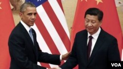 ປະທານາທິບໍດີ Barack Obama, ຊ້າຍ, ສຳພັດມືກັບ ປະທານປະເທດຈີນ ທ່ານ Xi Jinping.
