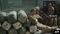 Американський солдат сидить на багажі, готуючи до повернення з Афганістану.