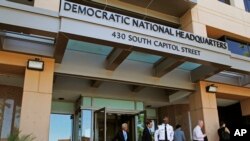 FILE - People stand outside the Democratic National Committee (DNC) headquarters in Washington.