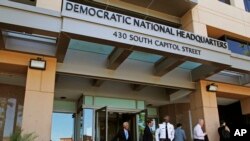 FILE - people stand outside the Democratic National Committee (DNC) headquarters in Washington. 