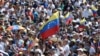 An opposition supporter waves a national flag during a gathering with Venezuelan opposition leader Juan Guaido, in Caracas on Feb. 2, 2019. 