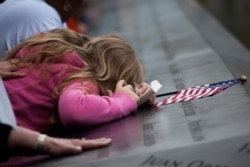 Family members visit the south reflecting pool during 10th anniversary ceremonies at the Sept. 11 memorial, Sunday Sept. 11, 2011, in New York. (AP Photo/Todd Heisler, Pool)