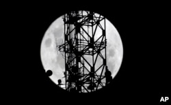The telecommunications tower' is pictured as the moon passes into the earth's shadow during a lunar eclipse as seen in in Johannesburg, South Africa, Jan. 31, 2018.