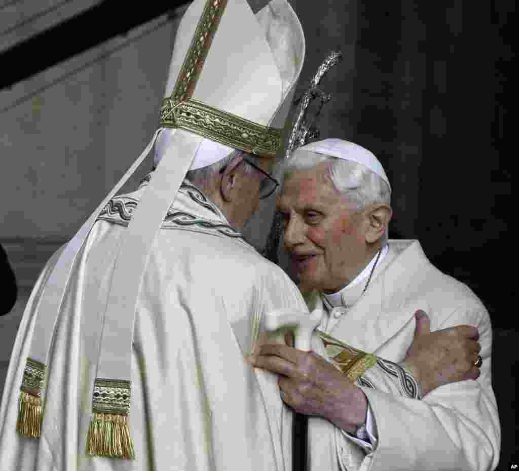 Pope Emeritus Benedict XVI, right, hugs Pope Francis in St. Peter&#39;s Basilica during the ceremony marking the start of the Holy Year, at the Vatican.