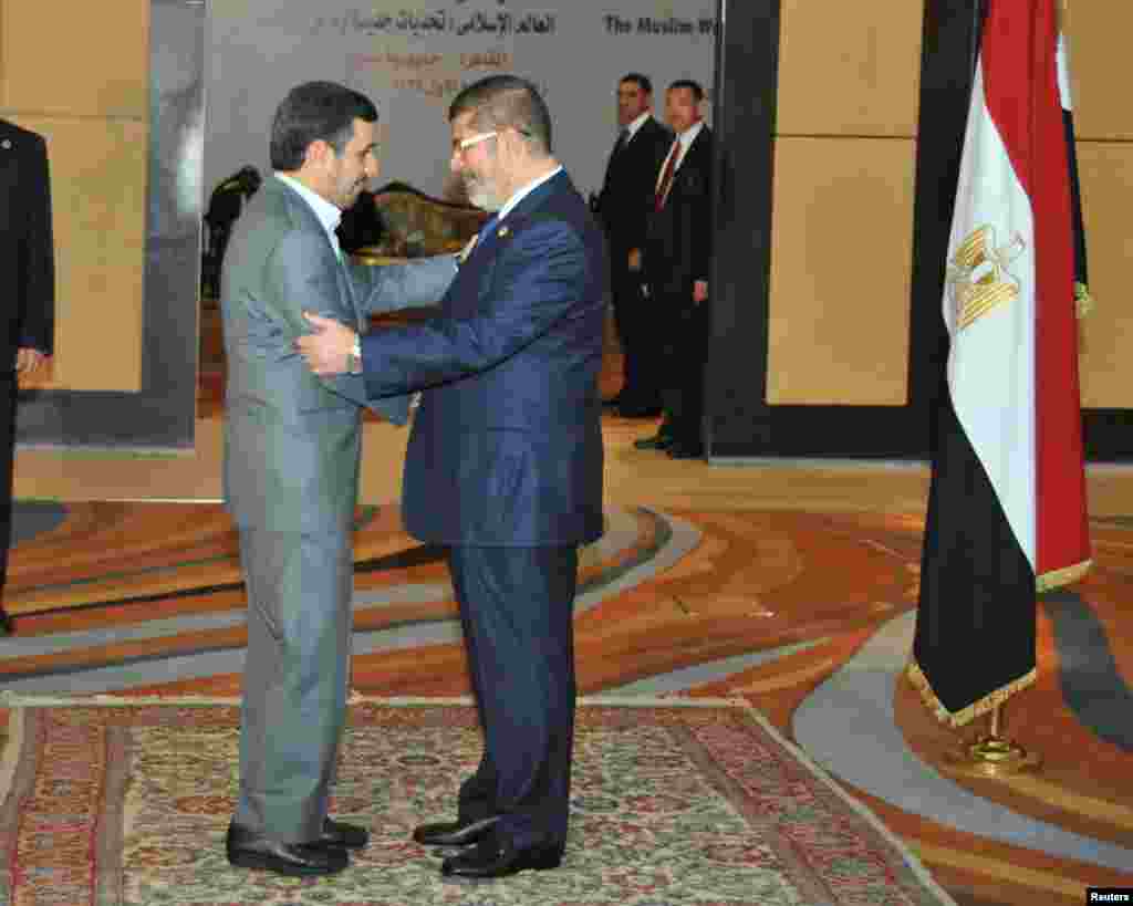 Presiden Mesir Mohammed Morsi menyapa Presiden Iran Mahmoud Ahmadinejad sebelum pembukaan KTT OKI di Kairo.