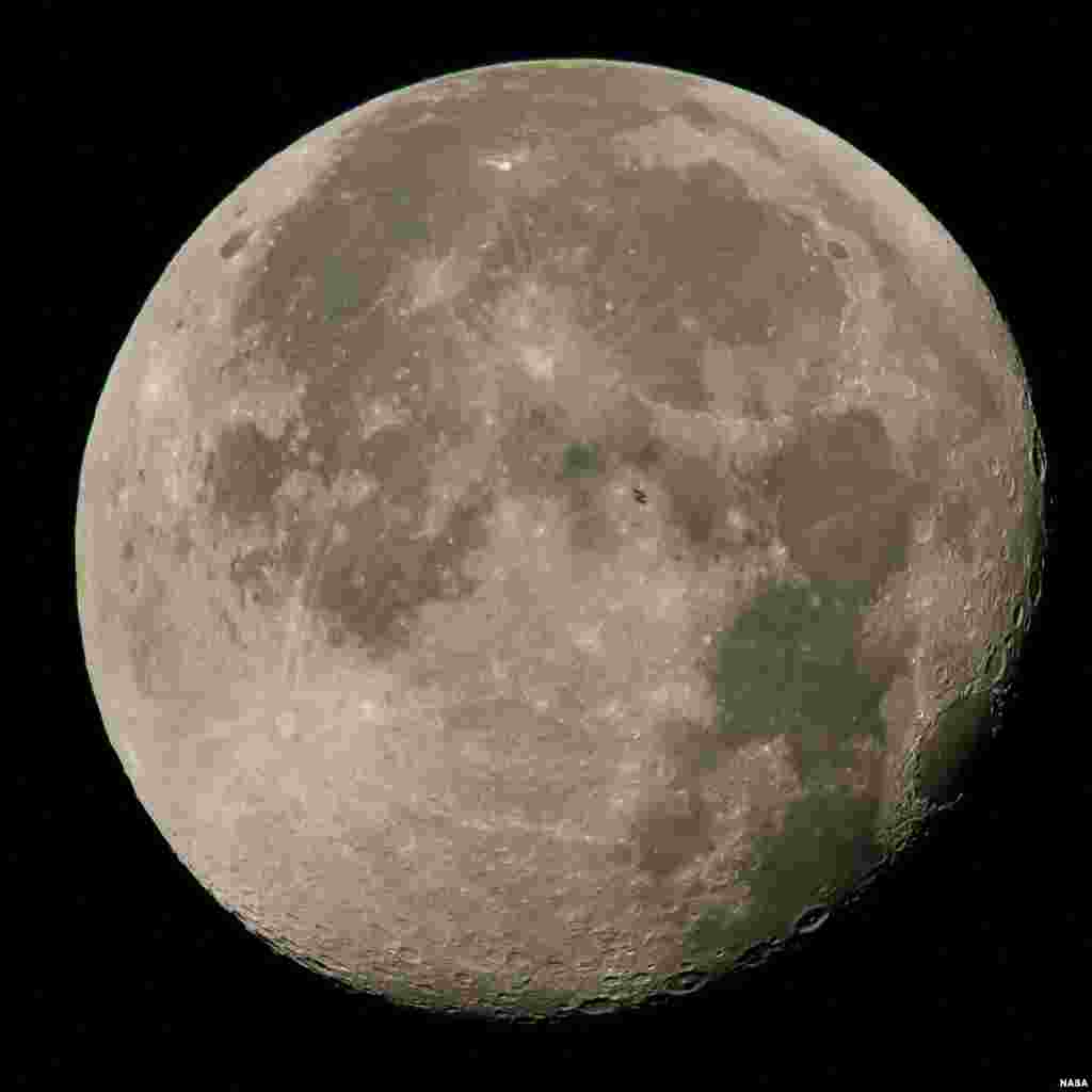 초속 약 5마일로 달을 통과하고 있는 국제우주정거장 실루엣이 달 표면에 비추어 보인다. 현재 국제우주정거장에는 6명의 우주인이 머물고 있다.