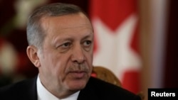FILE - Turkish President Recep Tayyip Erdogan, shown at news conference in Riga in October, could have his hold on government strengthened if his ally Hakan Fidan is elected to parliament.