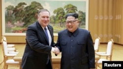 Le dirigeant nord-coréen Kim Jong Un serre la main du secrétaire d'Etat américain Mike Pompeo à Pyongyang, le 9 mai 2018 (KCNA).