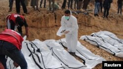 A rescue worker labels bags containing dead bodies of migrants who were washed up on a beach near the city of Zawiya, Libya Feb. 20, 2017. 