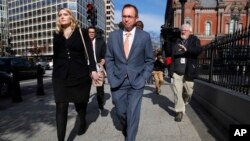 FILE - Mick Mulvaney, center, walks to the Eisenhower Executive Office Building after leaving the Consumer Financial Protection Bureau in Washington, Nov. 27, 2017. 