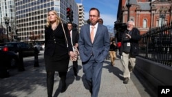Mick Mulvaney, center, walks to the Eisenhower Executive Office Building after leaving the Consumer Financial Protection Bureau in Washington, Nov. 27, 2017. 