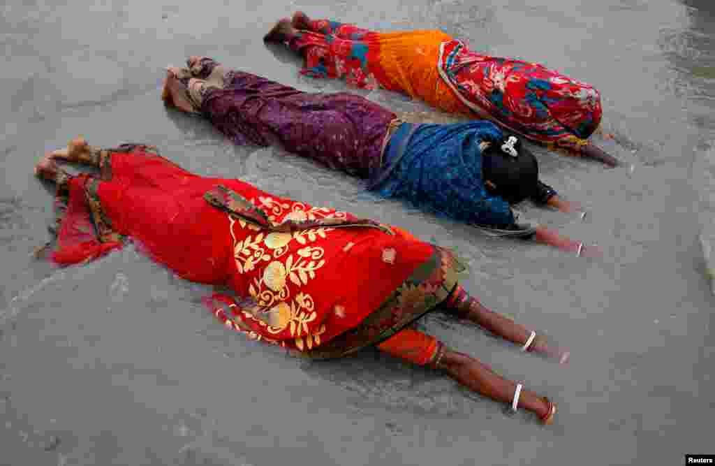 Women worship to Hindu sun god as they take a dip at the confluence of the river Ganges and the Bay of Bengal on the occasion of &quot;Makar Sankranti&quot; festival at the Sagar Island in the eastern state&nbsp;of West Bengal, India.