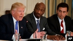 FILE - In this Feb. 23, 2017 photo, President Donald Trump, left, speaks during a meeting with manufacturing executives, including Merck CEO Kenneth Frazier, center, and Ford CEO Mark Fields. Frazier is resigning from the President’s American Manufacturin