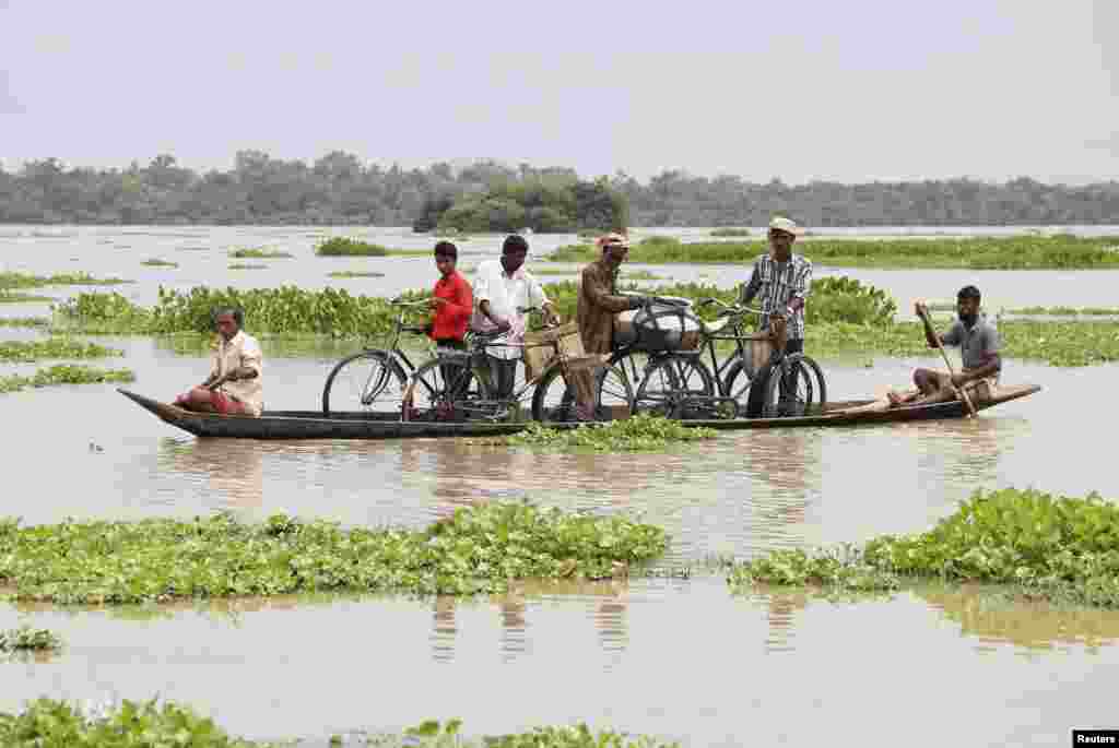 Villagers transport their bicycles on a boat through the flooded areas of the northeastern Indian state of Assam, Aug. 18, 2014