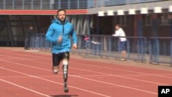 In this image taken on June 27, 2013, from TV provided by ab productions via APTN, Oscar Pistorius runs at the University of Pretoria, South Africa, during his first training session since the killing of girlfriend Reeva Steenkamp.