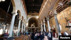 Egyptian security officials and investigators inspect the scene following a bombing inside Cairo's Coptic cathedral complex in Egypt, Dec. 11, 2016. 