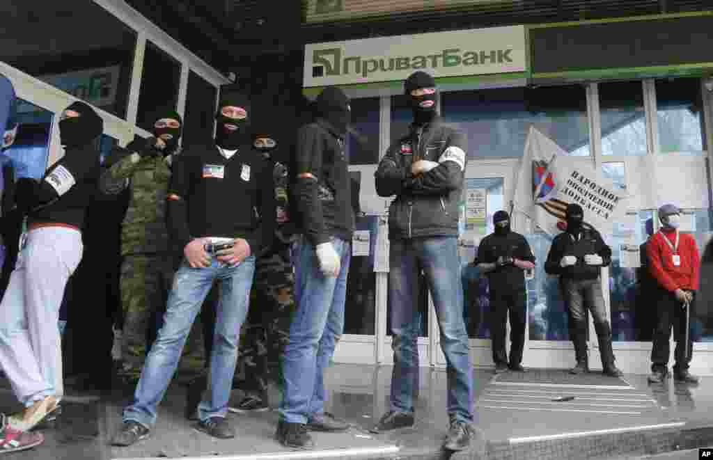 Masked pro-Russian activists block the office of a "Privatbank" bank, owned by a businessman who is considered a supporter of Ukraine's pro-Western government, Donetsk, April 28, 2014.