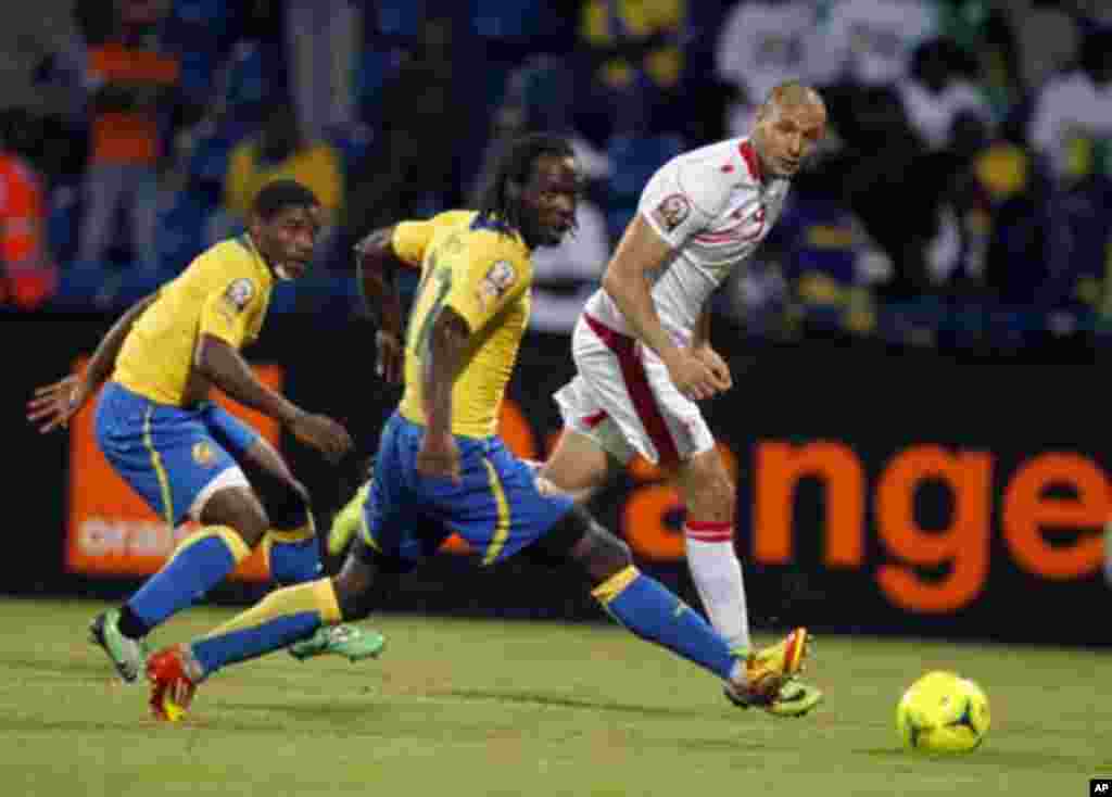 Tunisia's Yassine Chikaoui (R) challenges Eric Mouloungui (C) and Edmond Mouele of Gabon during their African Cup of Nations Group C soccer match at Franceville stadium in Gabon January 31, 2012.