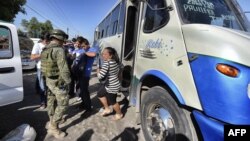 FILE - Mexican soldiers inspect vehicles at a checkpoint near Apatzingan community, state of Michoacan, Mexico, Jan. 12, 2015. A deadly clash erupted on Jan. 6, 2015, between federal forces and civilians in Apatzingan, killing at least nine people.