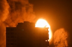 Smoke and flames rise above a building during Israeli air strikes, amid a flare-up of Israeli-Palestinian violence, in Gaza City May 17, 2021. REUTERS/Ibraheem Abu Mustafa