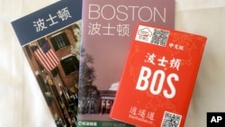In this March 23, 2017, photo, an activities guide, left, a city guide, center, and a pop-up map, right, all with Chinese translations, are displayed in a guest room at the Sheraton Boston Hotel in Boston.
