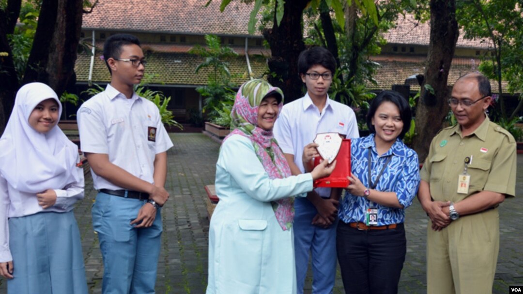 Pauline Arifin dari KPK menyerahkan plakat kepada Dwi Rini Wulandari Kepala Sekolah SMAN 3 Yogyakarta atas sikap jujur yang ditunjukkan para siswanya. (Foto: VOA/Munarsih Sahana)