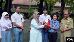 Pauline Arifin dari KPK menyerahkan plakat kepada Dwi Rini Wulandari Kepala Sekolah SMAN 3 Yogyakarta atas sikap jujur yang ditunjukkan para siswanya. (Foto: VOA/Munarsih Sahana)