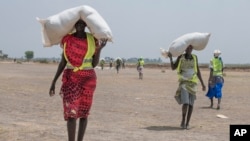 A women walk back to their homes after receiving food distributed by ICRC at a site in Leer County region of South Sudan, Tuesday, April 11, 2017. Two months after a famine was declared in two counties amid its civil war, hunger has become more widespread than expected, aid workers say, region on the brink of starvation and people at risk of dying without sustained food assistance.