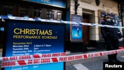 A police officer stands on duty next to a notice board is wrapped in police tape outside the Apollo theatre on the morning after part of it's ceiling collapsed on spectators as they watched a performance, in central London, Dec. 20, 2013.