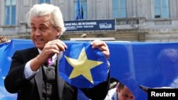 FILE - Dutch far-right Freedom Party leader Geert Wilders holds a star he cut from a European Union flag during a Eurosceptic rally in front of the EU Parliament in Brussels, Belgium, May 20, 2014.