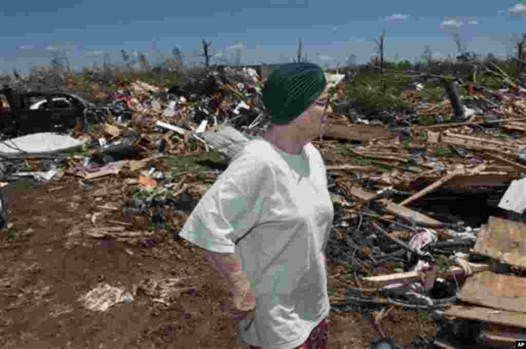 Yvone Engle surveys what is left of her home that she and her husband Elvis Ray Engle, survived the tornado that hit Phil Campbell Thursday April 27, 2011. The two where trapped in their bedroom when the storm hit but both came out with only scrapes. (AP/