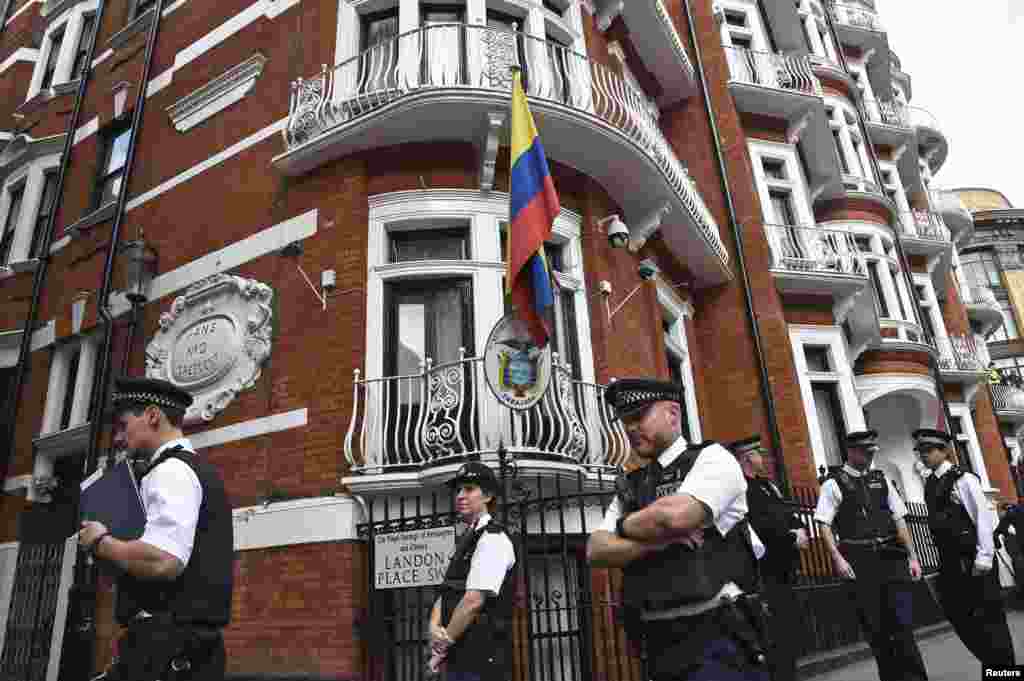 Police stand guard during a news conference by WikiLeaks founder Julian Assange at the Ecuadorian embassy, in central London, Aug. 18, 2014.