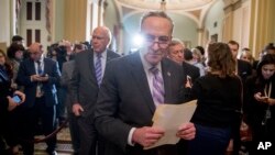 Senate Minority Leader Sen. Chuck Schumer of N.Y., center, and Sen. Patrick Leahy, D-Vt., center left, leave a new conference following a Senate policy luncheon after House and Senate negotiators worked out a border security compromise hoping to avoid another partial government shutdown.