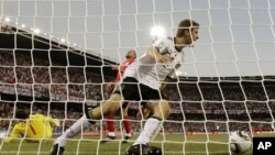Germany's Thomas Mueller (R) celebrates after scoring their fourth goal, as England goalkeeper David James (L) lies on the pitch during the World Cup round of 16 soccer match between Germany and England at Free State Stadium in Bloemfontein, South Africa,