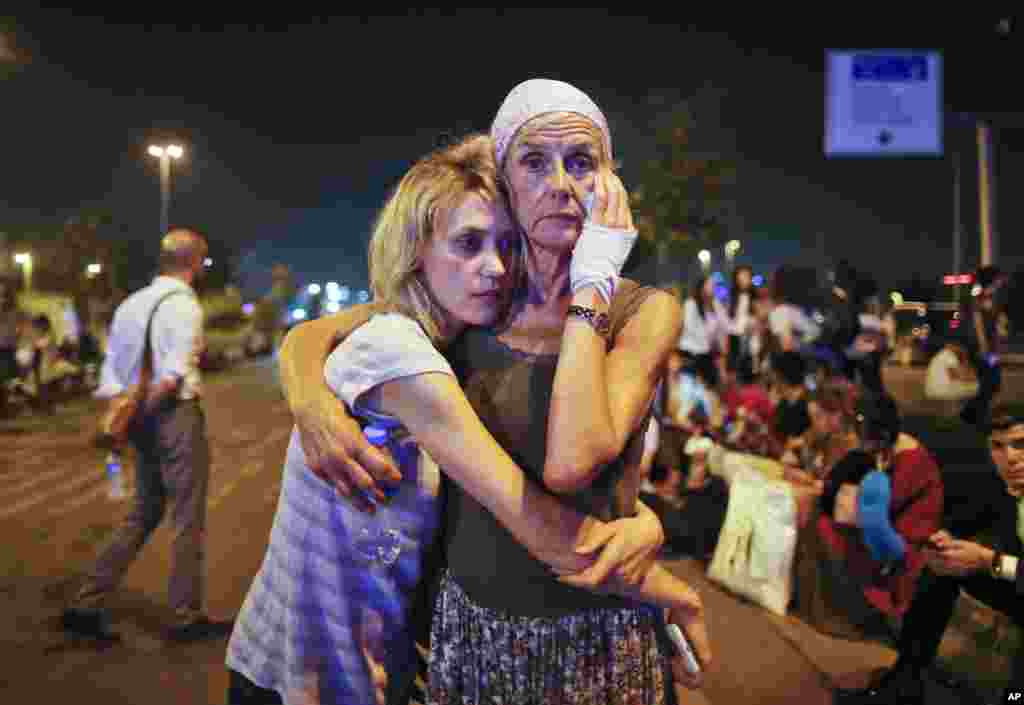 Passengers embrace each other early in the morning as they wait outside Istanbul&#39;s Ataturk airport in Turkey, following their evacuation in the wake of a number of explosions. The suicide bombing of the uspected Islamic State group extremists at the international terminal of the airport killed 41 people and wounded more than 200, said Turkish officials.