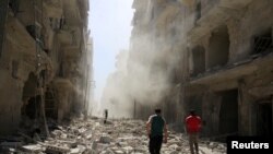 ພວກຜູ້ຊາຍ ກວດກາຄວາມເສຍຫາຍ ຫຼັງຈາກການໂຈມຕີ
ທາງອາກາດໃສ່ ຊຸມຊົນ al-Qaterji ຂອງເມືອງ Aleppo ທີ່ຖືກຄວບຄຸມໂດຍພວກກະບົດ. ຊີເຣຍ, 25 ກັນຍາ, 2016. 