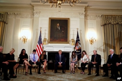 Presiden Donald Trump menundukkan kepalanya selama doa pembukaan pada awal sesi mendengarkan dengan siswa sekolah menengah dan guru di Ruang Makan Negara Gedung Putih di Washington, Rabu, 21 Februari 2018. (Foto: AP/Carolyn Kaster )