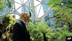 Jeff Bezos, the CEO and founder of Amazon.com, takes a walking tour of the Amazon Spheres, three plant-filed geodesic domes that serve as a work- and gathering place for Amazon employees on Monday, Jan. 29, 2018, in Seattle. (AP Photo/Ted S. Warren)